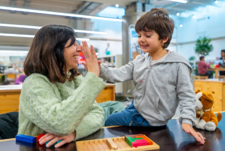 Au pair playing with the boy she takes care of